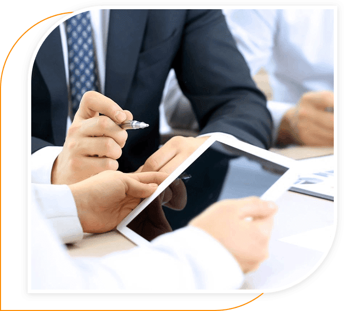 A group of people sitting at tables with papers and a tablet.