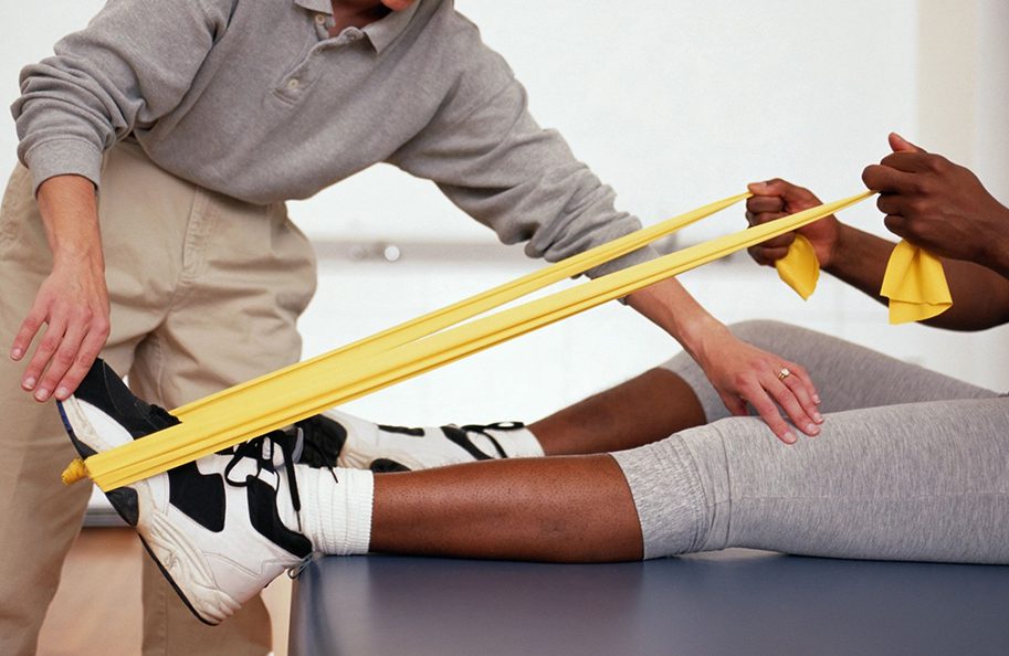 A person is being assisted by someone with a yellow band.