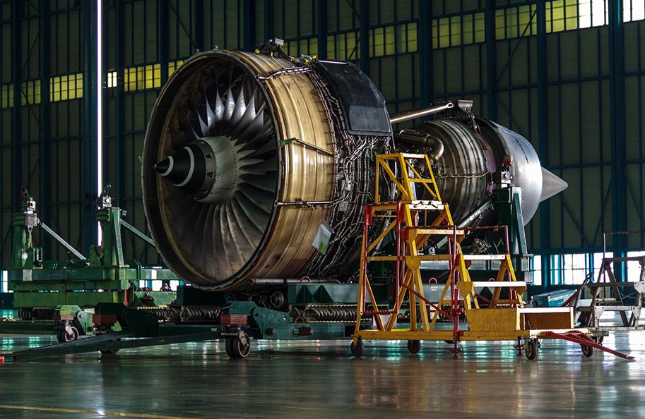 A large jet engine in an airplane hanger.