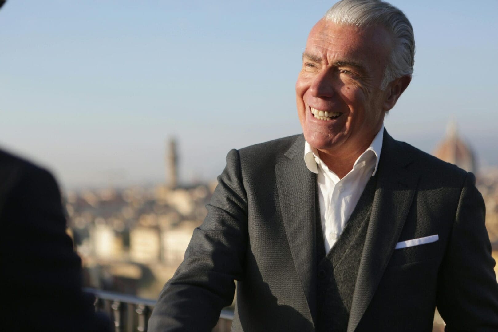 A man in a suit and tie smiling.